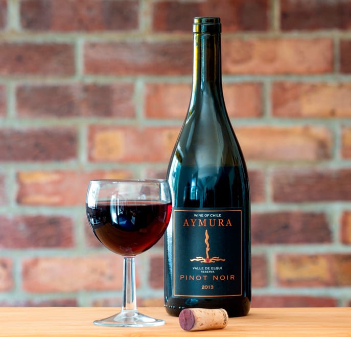 Botella y copa de vino tinto Aymura Pinot Noir Reserva 2013 del Valle de Elqui, Chile, servido en el restaurante Peix & Brases.